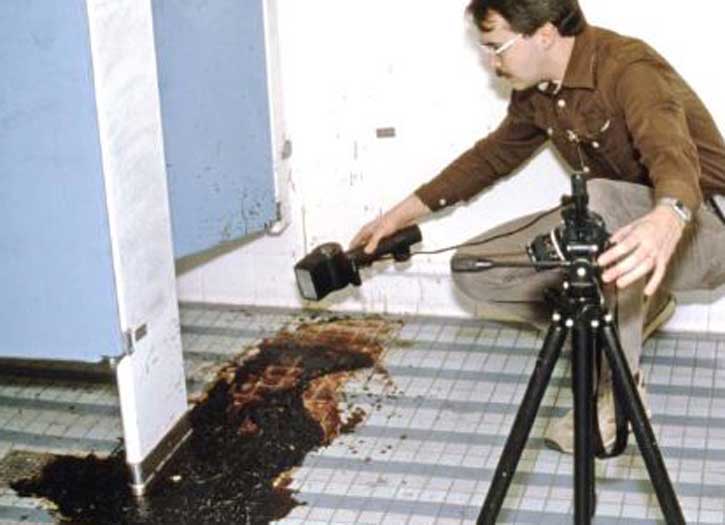 Crime Scene Investigator photographing bloodstain evidence